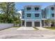 Beautiful three-story townhome with blue and gray exterior, individual garages, and well-kept surroundings at 1237 Savona Ne Dr, St Petersburg, FL 33702