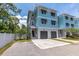 Three-story townhome with blue and gray siding, a two-car garage, and tidy landscaping at 1237 Savona Ne Dr, St Petersburg, FL 33702