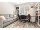 Cozy office space with gray sofa, hardwood floors, and a wooden desk with natural light at 1237 Savona Ne Dr, St Petersburg, FL 33702