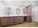Bathroom featuring double sink vanity with wood cabinets and white countertop, wood flooring and a separated toilet at 1520 Gulf Blvd # 404, Clearwater, FL 33767