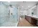 Beautiful bathroom with glass shower door, patterned tiles, and view of the double sink vanity and the main bedroom at 1520 Gulf Blvd # 404, Clearwater, FL 33767