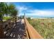 Scenic boardwalk leading to a pristine beach with clear blue skies, lush vegetation and relaxing sands at 1520 Gulf Blvd # 404, Clearwater, FL 33767