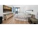 Bedroom with ocean view, dresser, large television, and hardwood floors at 1520 Gulf Blvd # 404, Clearwater, FL 33767