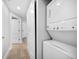 Laundry room features a stacked washer and dryer, with hallway showing multiple doors at 1520 Gulf Blvd # 404, Clearwater, FL 33767