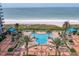 Aerial view of a uniquely shaped pool and beach with lounge chairs at 1520 Gulf Blvd # 404, Clearwater, FL 33767