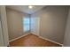 Cozy bedroom with light wood floors, neutral walls, and a bright window with shutters at 15209 Arbor Hollow Dr, Odessa, FL 33556