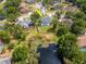 Aerial view of a home and pond with trees and lush lawns in a serene community at 17205 Tiffany Shore Dr, Lutz, FL 33549