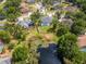 Aerial view of a home and pond with trees and lush lawns in a serene community at 17205 Tiffany Shore Dr, Lutz, FL 33549