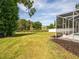 Expansive grassy backyard featuring green space and a screened lanai at 17205 Tiffany Shore Dr, Lutz, FL 33549