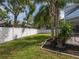 Spacious backyard with a white privacy fence, lush greenery, and a tropical landscaped border at 17205 Tiffany Shore Dr, Lutz, FL 33549