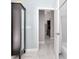 Elegant bathroom features sleek modern vanity, a large dark wood cabinet and marble floors with a view of the kitchen at 17205 Tiffany Shore Dr, Lutz, FL 33549