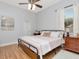 Comfortable bedroom features a ceiling fan, natural light, and hardwood flooring at 17205 Tiffany Shore Dr, Lutz, FL 33549