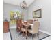 Chic dining room featuring a large window, a chandelier, and a wooden table for eight at 17205 Tiffany Shore Dr, Lutz, FL 33549