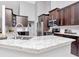 Modern kitchen featuring stainless steel appliances, granite countertops, and dark wood cabinets at 17205 Tiffany Shore Dr, Lutz, FL 33549