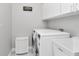 Functional laundry room with a washer, dryer, storage cabinets, and a utility sink at 17205 Tiffany Shore Dr, Lutz, FL 33549