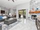 Spacious living room with a stone fireplace, tile floors, and a sliding door to the lanai at 17205 Tiffany Shore Dr, Lutz, FL 33549