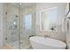 Bathroom features a glass enclosed shower, stand alone tub, and marble accents, enhanced by natural light at 1739 1/2 Bayou Grande Ne Blvd, St Petersburg, FL 33703
