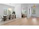 Bright dining room featuring light wood floors, modern chandelier, and sunlit windows at 1739 1/2 Bayou Grande Ne Blvd, St Petersburg, FL 33703