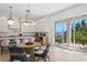 Open floor plan kitchen features an island, light wood floors, dining table, and waterfront views at 1739 1/2 Bayou Grande Ne Blvd, St Petersburg, FL 33703