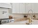Bright kitchen features white cabinets, neutral backsplash, pot filler, and gourmet gas range at 1739 1/2 Bayou Grande Ne Blvd, St Petersburg, FL 33703