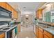 Well-lit kitchen with wooden cabinetry and a view into the dining area, complete with a double sink and appliances at 1809 Stancel Dr, Clearwater, FL 33764
