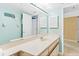 Bright bathroom featuring a single sink vanity, large mirror and blue accent wall at 18400 Gulf Blvd # 1109, Indian Shores, FL 33785