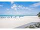 Expansive beach scene featuring white sand, clear blue water and beach chairs with umbrellas at 18400 Gulf Blvd # 1109, Indian Shores, FL 33785