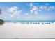 Expansive white sandy beach with blue umbrellas and the Gulf of Mexico's calm waters at 18400 Gulf Blvd # 1109, Indian Shores, FL 33785