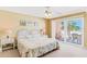 Cozy bedroom with a white wicker bed frame and access to a private balcony with beautiful ocean views at 18400 Gulf Blvd # 1109, Indian Shores, FL 33785