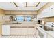 Open-concept kitchen featuring white appliances and a passthrough to the living area, providing a seamless flow and ocean views at 18400 Gulf Blvd # 1109, Indian Shores, FL 33785