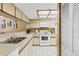 A well-lit kitchen featuring modern appliances, light countertops, and ample cabinet space and a pass-through to the dining room at 18400 Gulf Blvd # 1109, Indian Shores, FL 33785