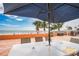 Outdoor patio with a large table and umbrella, offering serene views of the beach and ocean at 18400 Gulf Blvd # 1109, Indian Shores, FL 33785