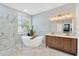 Bright bathroom featuring modern tub, shower, double sink and wood cabinets at 19246 Meadow Pine Dr, Tampa, FL 33647