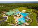 Aerial view of a community pool with swimming areas, a waterslide, a playground and lush landscaping at 19246 Meadow Pine Dr, Tampa, FL 33647