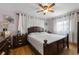 This bedroom features hardwood floors, a ceiling fan, and custom draperies at 2167 Euclid E Cir, Clearwater, FL 33764