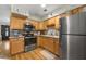 Well-lit kitchen featuring wood cabinets, stainless steel appliances and hardwood floors at 2167 Euclid E Cir, Clearwater, FL 33764
