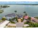High aerial view of three homes with a bay view, lush lawns, and lavish landscaping at 2250 Donato Dr, Belleair Beach, FL 33786