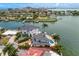 Beautiful waterfront home with a pool and dock, surrounded by lush landscaping and bay waters at 2250 Donato Dr, Belleair Beach, FL 33786