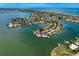 Aerial view showcases waterfront homes with lush landscaping and private docks in bay community at 2250 Donato Dr, Belleair Beach, FL 33786