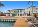 Waterfront home with a modern deck, pool, private dock, and patio seating at 2250 Donato Dr, Belleair Beach, FL 33786