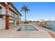 The backyard features a waterfront pool, private dock, and modern deck at 2250 Donato Dr, Belleair Beach, FL 33786