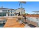 A waterfront house featuring a boat dock with seating and boat lift near the rear patio and pool at 2250 Donato Dr, Belleair Beach, FL 33786