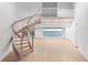 Elegant foyer features a unique curved staircase, opening up to panoramic water views through expansive glass doors at 2250 Donato Dr, Belleair Beach, FL 33786
