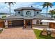 Stunning waterfront home with a paver driveway, two-car garage, and a well-manicured lawn at 2250 Donato Dr, Belleair Beach, FL 33786