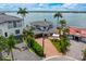 Stunning waterfront home with a paver driveway, two-car garage, and beautifully landscaped yard at 2250 Donato Dr, Belleair Beach, FL 33786