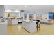 Modern white kitchen with an island and stainless steel appliances, and access to dining area at 2250 Donato Dr, Belleair Beach, FL 33786