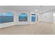 Expansive living area featuring arched windows and a sliding glass door with scenic waterfront views, enhancing natural light at 2250 Donato Dr, Belleair Beach, FL 33786