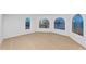 Bright living room featuring arched windows with picturesque waterfront views, and white wall paint at 2250 Donato Dr, Belleair Beach, FL 33786