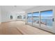 Spacious living room with water views from large windows, leading to a private balcony at 2250 Donato Dr, Belleair Beach, FL 33786