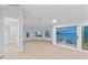Bright living room features arched windows and sliding doors, offering panoramic views of the water and surrounding landscape at 2250 Donato Dr, Belleair Beach, FL 33786